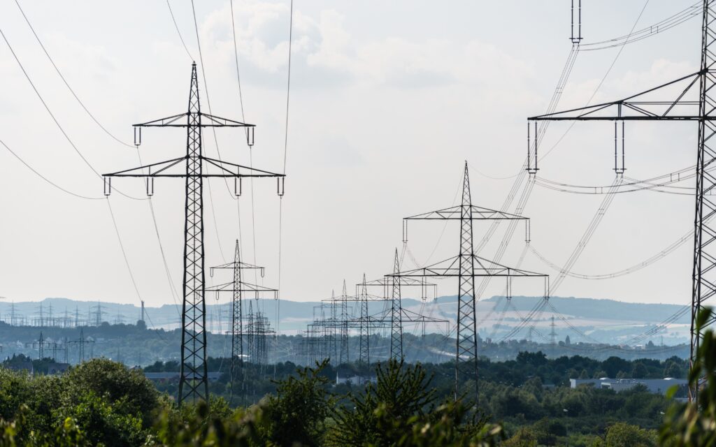 high voltage lines and power pylons in a green lan 2026 03 20 03 20 46 utc